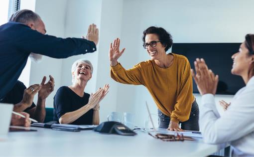 Group of happy, engaged employees giving each other high fives